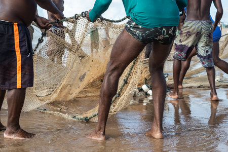 Half body of unidentified fishermen pulling a fishing net. Fishing hobby. Brazilの写真素材