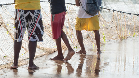 Half body of unidentified fishermen pulling a fishing net. Fishing hobby. Brazilの写真素材