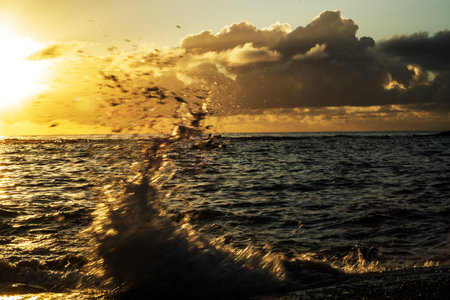 Waves crashing with splash on the shore of a beach at sunrise. Dramatic landscape. Environment....