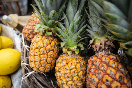 Pineapple for sale at a street market. Tropical fruit from the bromeliad family, native to South America. Rich in nutrients and health benefits. Food for sale.の写真素材