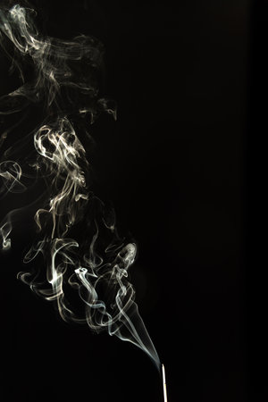 Burning incense with smoke on a black background. Studio shot.の写真素材