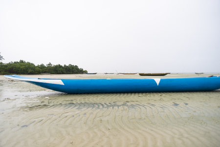Blue fishing canoe anchored on the sand of a dry beach. Very rainy day with dense clouds. Brazilの写真素材