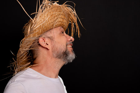 Bearded man wearing a white shirt and a straw hat representing a character from the festival of Sao Joao in Brazil. Traditional festival.の写真素材