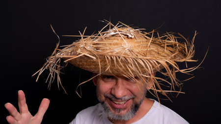Bearded man wearing a white shirt and a straw hat representing a character from the festival of Sao Joao in Brazil. Traditional festival.の写真素材