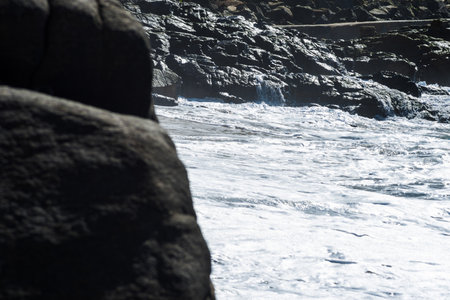 Wet dark rocks on the edge of a beach. hot summer day. Natureの写真素材