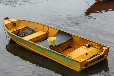 A mighty river with anchored fishing and transport boats and canoes. Rainy and cold day.の写真素材