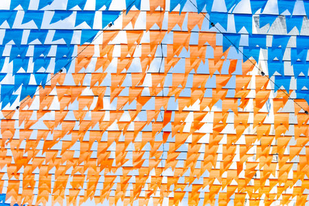 Colorful banners used to decorate the June festivities. Plastic objects are hung high up....