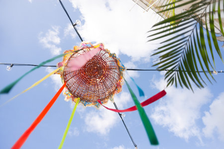 Straw basket decorated with colorful ribbons attached to electrical wires. Feast of Saint John. Pelourinho, Brazil.の写真素材