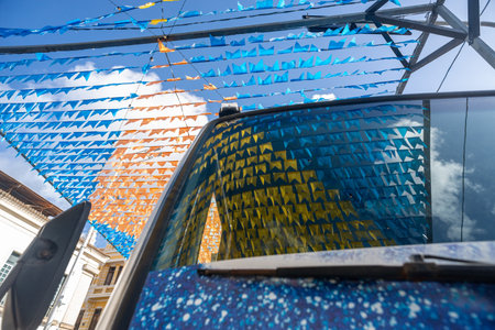 Decoration of the June festival with colorful flags. Plastic objects attached to the top. Pelourinho, Brazil.の写真素材