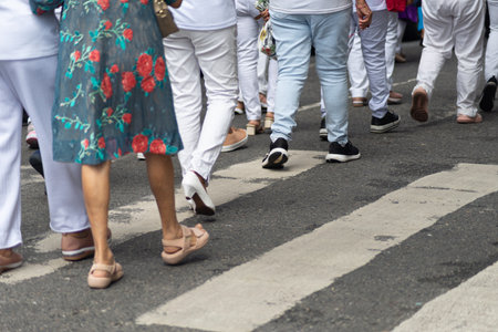 Half-body photo of unidentified people walking on a pedestrian crossing. Salvador, Brazil