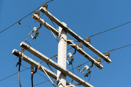 The top of a power pole with a tangle of electrical, internet, and telephone wires and cables....