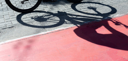 Shadow of a bicycle projected onto a cycle path. Person exercising. Cyclist in action. Lifestyle, sports practice.の写真素材