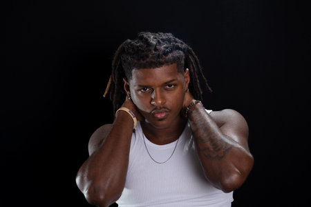 Salvador, Bahia, Brazil - August 30, 2025: Handsome young man with dreadlocks and hands on his neck...