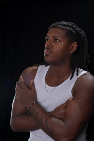 Salvador, Bahia, Brazil - August 30, 2025: Handsome young man with dreadlocks posing for a studio...