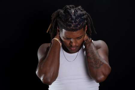 Salvador, Bahia, Brazil - August 30, 2025: Handsome young man with dreadlocks and hands on his neck...
