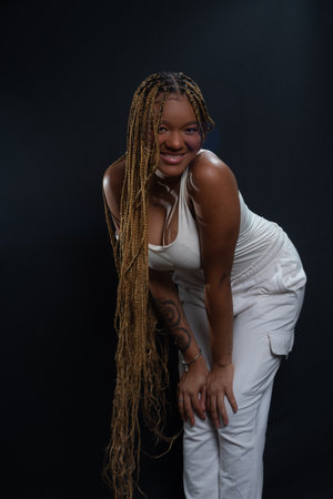 Salvador, Bahia, Brazil - August 30, 2025: Young woman with braided hair posing for a studio photo...