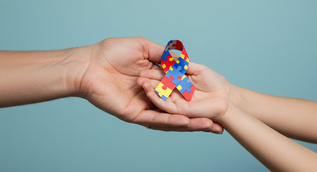 hands holding puzzle ribbon symbolizing autism awareness.の素材