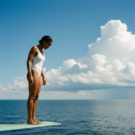A solitary woman in a white swimsuit stands poised on a diving board, gazing downward against a vast, cloudy blue sky. This image conveys calm, anticipation, and freedom.の素材