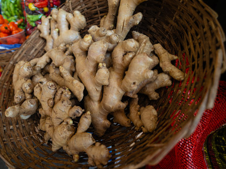Vibrant market scene featuring fresh ginger roots in a woven basket, highlighting natural, earthy spice perfect for cooking and healthy, everyday meals.の写真素材