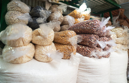 A vibrant market display showcases almonds and peanuts packed in clear plastic bags, neatly stacked for shoppers to enjoy.の写真素材