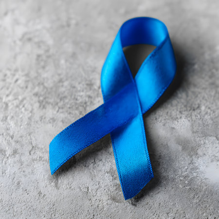 Close-up of a blue ribbon placed on a gray stone surface, representing the Blue November campaign for prostate cancer awareness and prevention.の素材