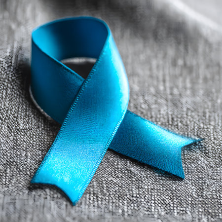 Close-up of a blue ribbon placed on a gray stone surface, representing the Blue November campaign for prostate cancer awareness and prevention.の素材