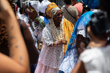 Salvador, Bahia, Brazil - November 25, 2025: A group of Bahian women in white lace clothing and colorful skirts are seen in a procession in Pelourinho, Salvador, Bahia.のeditorial素材