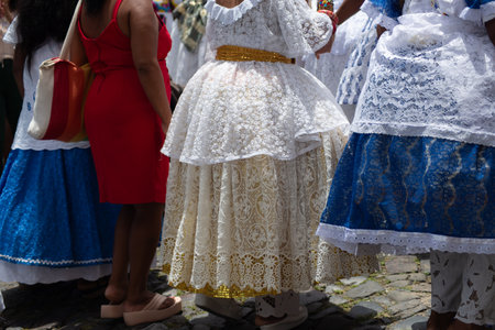 Salvador, Bahia, Brazil - November 25, 2025: A group of Bahian women in white lace clothing and colorful skirts are seen in a procession in Pelourinho, Salvador, Bahia.のeditorial素材