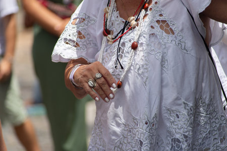 Salvador, Bahia, Brazil - November 25, 2025: Close-up of the torso and hands of a Baiana de AcarajÃ©, participating in the Baianas Day celebration in Pelourinho, Salvador, Bahia.のeditorial素材