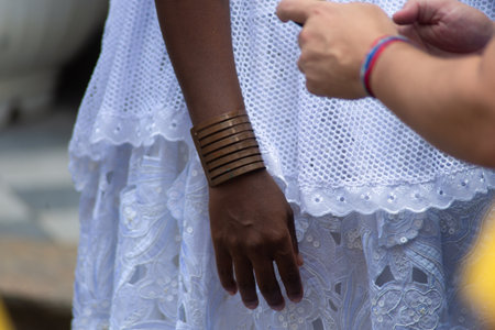 Salvador, Bahia, Brazil - November 25, 2025: Close-up of the torso and hands of a Baiana de AcarajÃ©, participating in the Baianas Day celebration in Pelourinho, Salvador, Bahia.のeditorial素材