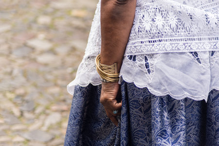 Salvador, Bahia, Brazil - November 25, 2025: Close-up of the torso and hands of a Baiana de AcarajÃ©, participating in the Baianas Day celebration in Pelourinho, Salvador, Bahia.のeditorial素材