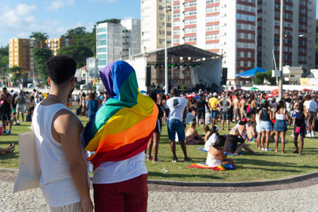Salvador, Bahia, Brazil - September 14, 2025: Two men with their backs turned are seen holding a rainbow flag while observing an LGBT event in Salvador, Bahia.のeditorial素材