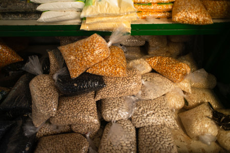 Detail of packages of black-eyed peas, black beans, and popcorn kernels arranged on a stall,...