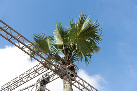 Salvador, Bahia, Brazil - January 23, 2026: Low angle of metal support structures for stages or VIP boxes against the sky with trees and clouds. Salvador, Bahia.のeditorial素材