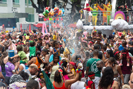 Salvador, Bahia, Brazil - February 14, 2026: Revelers celebrate street Carnival amidst a shower of foam and artificial snow, showing off costumes and great joy. Salvador, Bahia.のeditorial素材