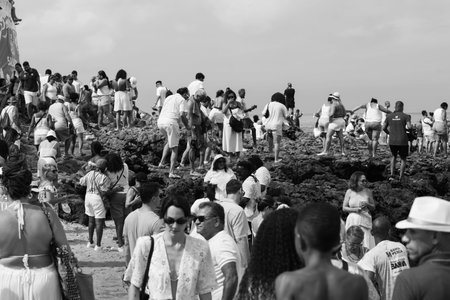 Salvador, Bahia, Brazil - February 2, 2026: Black and white portrait of people walking on stones...