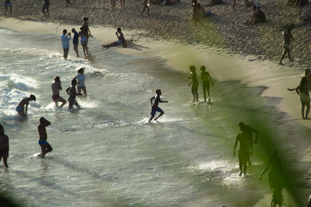 Salvador, Bahia, Brazil - January 11, 2026: Dozens of people are seen swimming in the sea at...