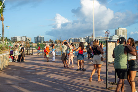 Salvador, Bahia, Brazil - January 11, 2026: Couples dancing on a wooden deck with the city and sea in the background. Salvador, Bahiaのeditorial素材