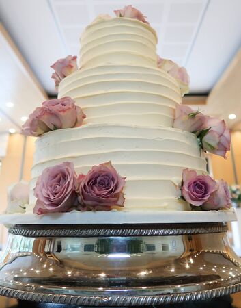 Amazing White Wedding Cake with Pink Flowers on Silver Standの写真素材
