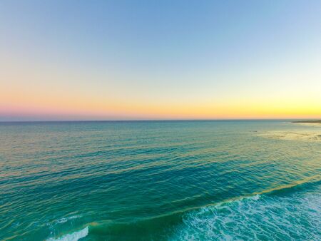 Sun Setting Over Ocean Beach Frontの写真素材