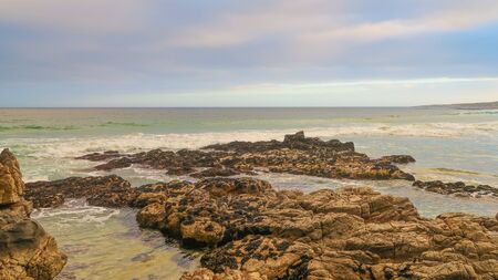 Rocks on the Beach with Clouds, Waves and Ocean