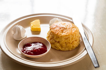 English scones set served on a table next to window, illuminated with natural lightの写真素材