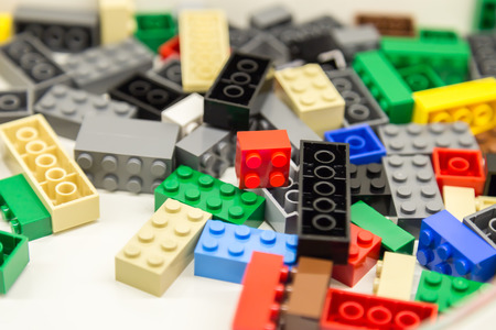 Pile of Building Blocks with focus and highlight on a selected piece with available lightの写真素材