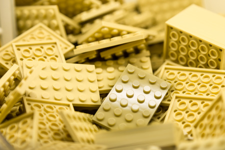 Pile of Building Blocks with focus and highlight on a selected piece with available lightの写真素材