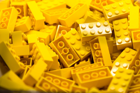 Pile of Building Blocks with focus and highlight on a selected piece with available lightの写真素材