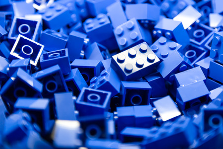 Pile of Building Blocks with focus and highlight on a selected piece with available lightの写真素材