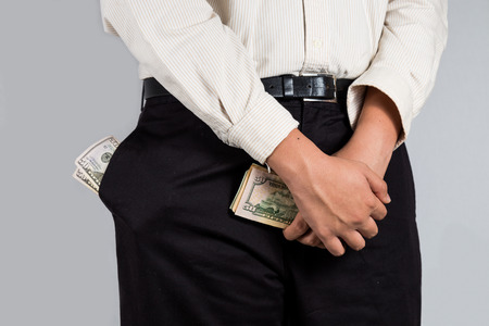 Man with abundant of money in his pockets, holding some notes