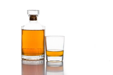 Whiskey bottle with a glass of whiskey isolated in whiteの写真素材