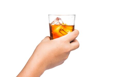 Hand holding a glass of scotch brandy on the rockの写真素材
