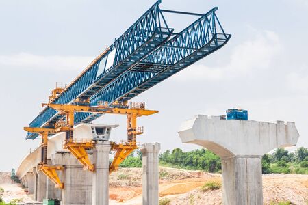 Construction of a mass transit train line in progress with heavy infrastructure. This photo shows the progress in joining the various blocks/modules of the line with heavy equipment.の写真素材